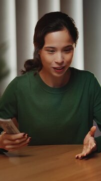 Successful Asian female business coach conducts video lecture about finances