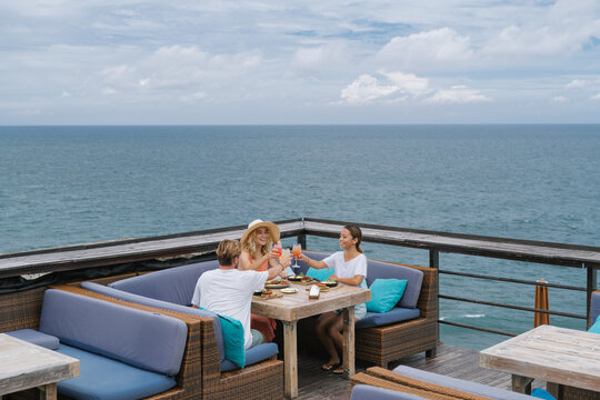 Friends Sharing a Coastal Meal at a Cliffside Cafe