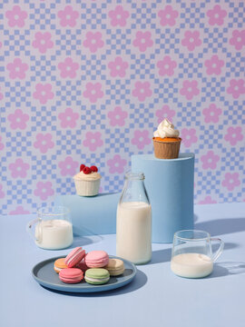 A charming arrangement of colorful macarons, cupcakes and milk