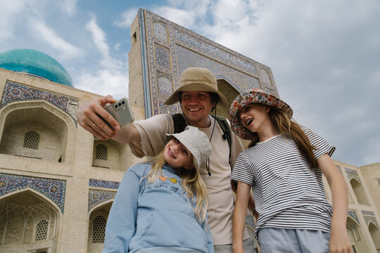 Father and two daughters taking a selfie near the Kalyan Minaret.