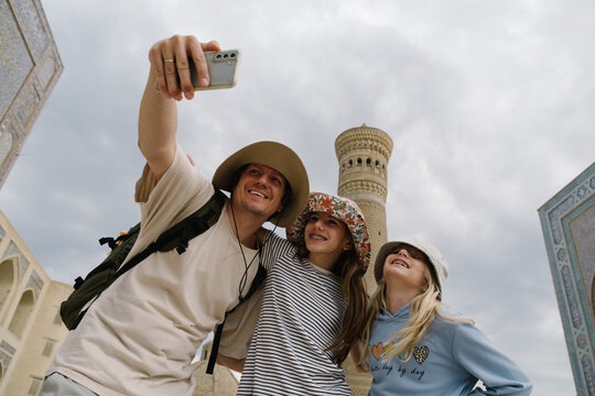 Father and two daughters taking a selfie near the Kalyan Minaret.