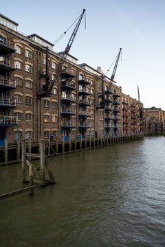 Historic Dockside Warehouse And Crane Beside River Thames In London