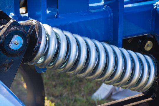 Steel silver spring as part of heavy agricultural, industrial machine. Technology