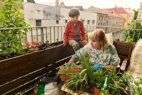 Grandmother and Grandson Gardening on Urban Balcony