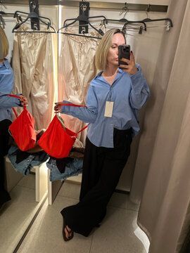 Woman Taking Mirror Selfie in Clothing Store Fitting Room
