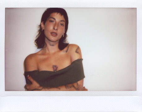 Unfocused UGC Polaroid of Tattooed woman in off-shoulder top
