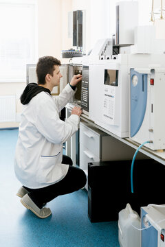 A laboratory assistant works with a chromatographic device.