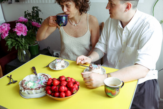 A couple is spending time in the kitchen.
