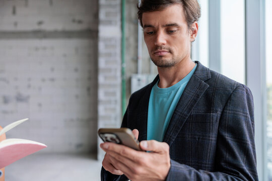 Businessman checking his phone in an unfinished office space