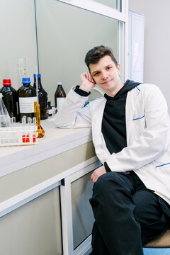 A chemist is sitting in a laboratory with samples and equipment.
