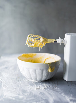 Mixing raw cake dough in a bowl with an electric mixer