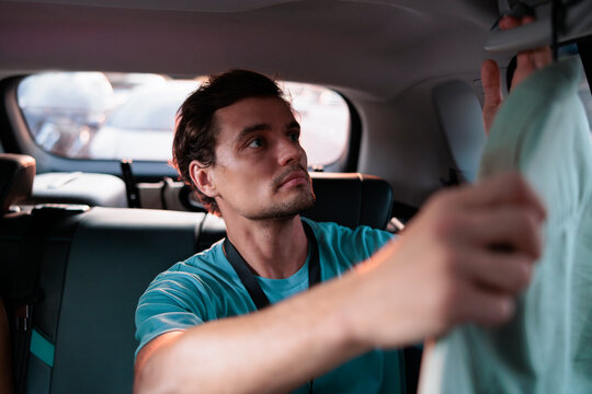 Man hanging clothes in a car at sunset
