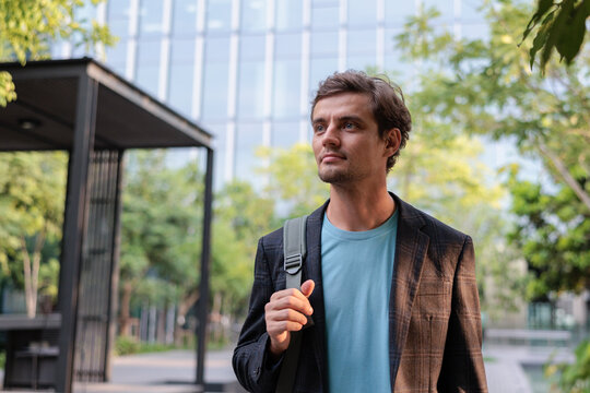 A stylish young man walking through a modern city