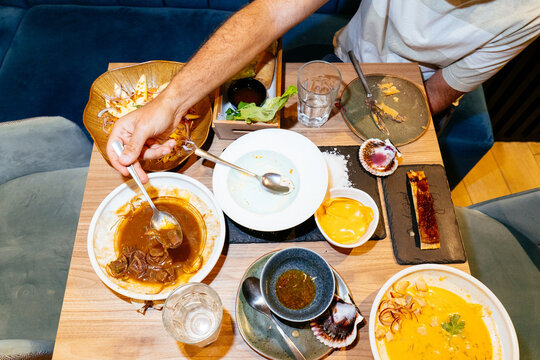 Person enjoying lunch at restaurant with multiple dishes