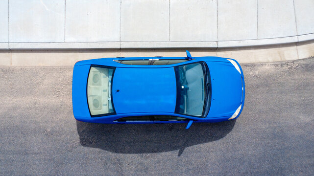 Blue car viewed from above on road