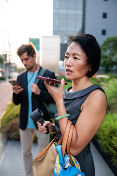 Businesswoman talks on her smartphone in an urban setting.