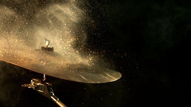 Golden Glitter Explosion From Cymbal on Black Background