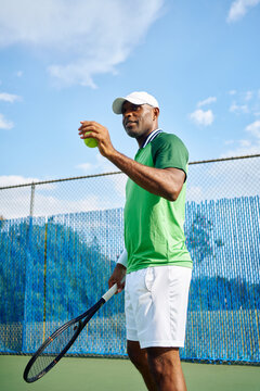 Active mid adult tennis player preparing to serve