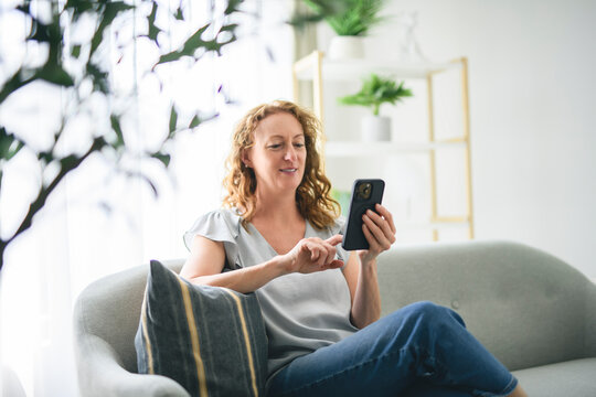 Happy mature 50 years woman with cellphone on lifestyle portrait