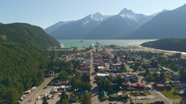 An aerial view shows the coastal town of Skagway, Alaska nestled between steep mountains and the ocean harbor. July 21, 2025. 