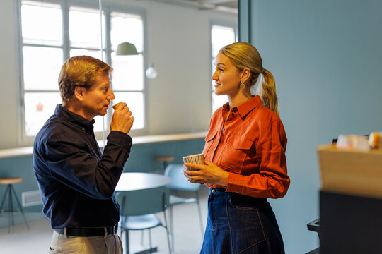 Two workers having a conversation during coffee break together