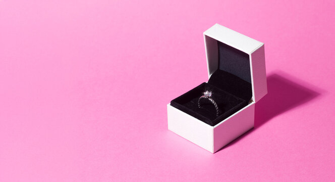 Sparkling Diamond Engagement Ring in Box on Pink Background