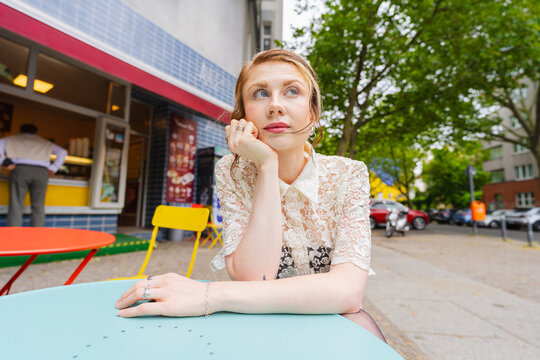 Woman Daydreaming at Outdoor Cafe