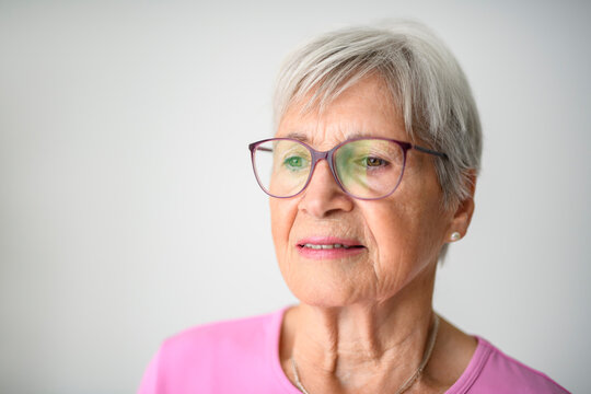 Portrait of elderly woman with eyeglasses over studio white