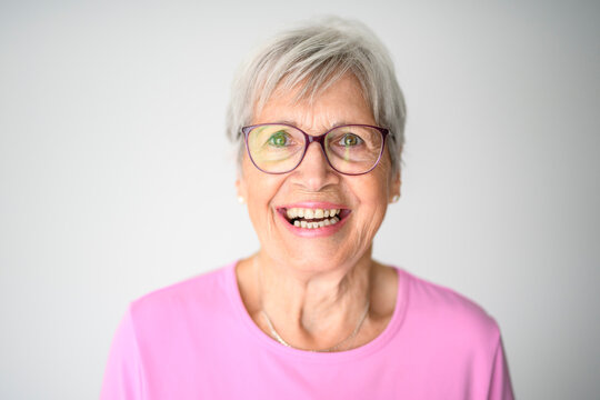 Portrait of elderly woman with eyeglasses over studio white