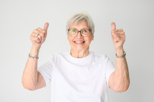 Portrait of elderly woman with eyeglasses over studio white