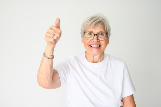 Portrait of elderly woman with eyeglasses over studio white