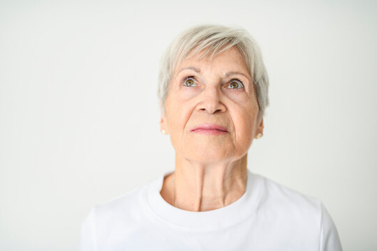 Portrait of elderly woman with eyeglasses over studio white