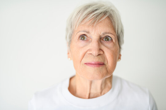 Portrait of elderly woman with eyeglasses over studio white
