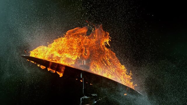 Super slow motion footage at 1000 fps of a burning cymbal with explosive flames and sparks, capturing intricate fire movement, combustion, heat, and metallic reflections.