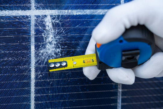 Technician Measuring Impact Damage on a Solar Panel