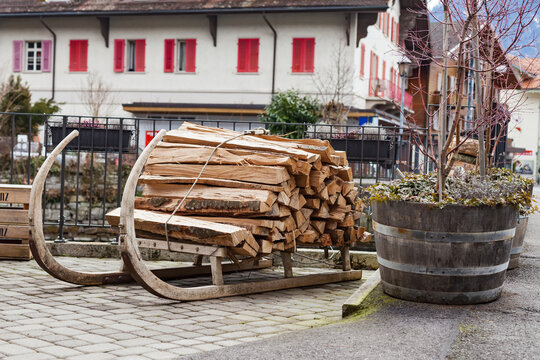 Firewood Stacked on a Traditional Wooden Sled in Alpine Village