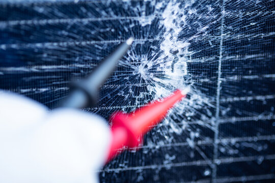 Technician Testing a Cracked Solar Panel with Multimeter Probes