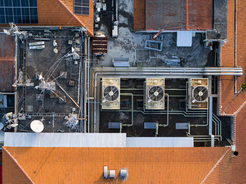 Aerial view of the Nusa Dua Resort Area Road rooftops featuring industrial HVAC units, solar panels, and complex piping systems in Kecamatan Kuta Selatan, Bali, Indonesia.