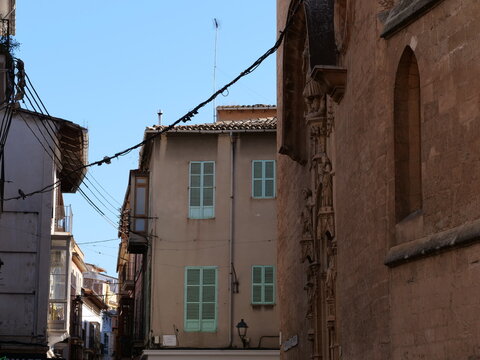 Historic European Alley with Gothic Stone Facade and Green Shutters
