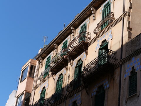 Catalan Modernist Building Facade with Blue Ceramic Tiles and Wrought Iron Balconies