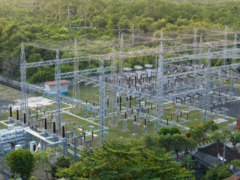 Aerial view of Nusa Dua Substation featuring electrical infrastructure, metal towers, and power lines surrounded by lush green vegetation in Kecamatan Kuta Selatan, Bali, Indonesia.