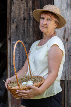 Woman farmer holding basket of fresh farm eggs