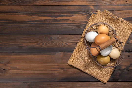 Farm fresh eggs in basket on rustic wooden table