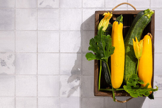 Fresh zucchini and yellow squash with blossoms in crate