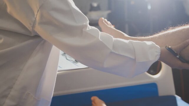 Physical therapist performing ankle examination on patient in clinic