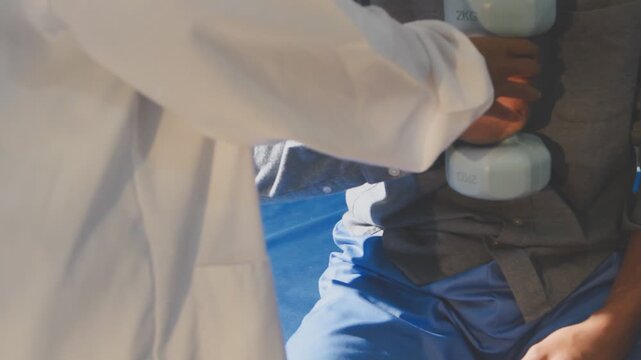 Physical therapist performs shoulder range of motion test on male patient