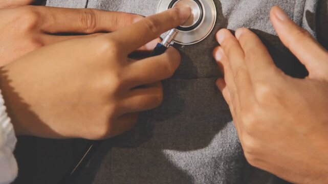 Doctor use stethoscope, checking up heart beat, auscultation in doctor office at hospital. Patient worker has to get medical checkup every year for her health or
