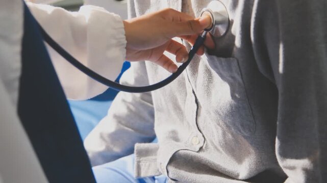 Doctor use stethoscope, checking up heart beat, auscultation in doctor office at hospital. Patient worker has to get medical checkup every year for her health or
