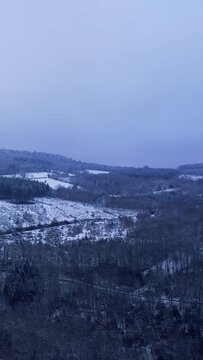 Vertical 9:16 video showing a wide view of the snow-covered Morvan forest landscape at Haut Folin in Burgundy, France.