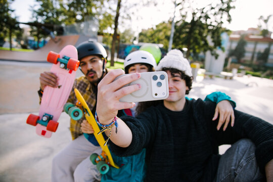 Gen Z friends take selfie with skateboard at skatepark